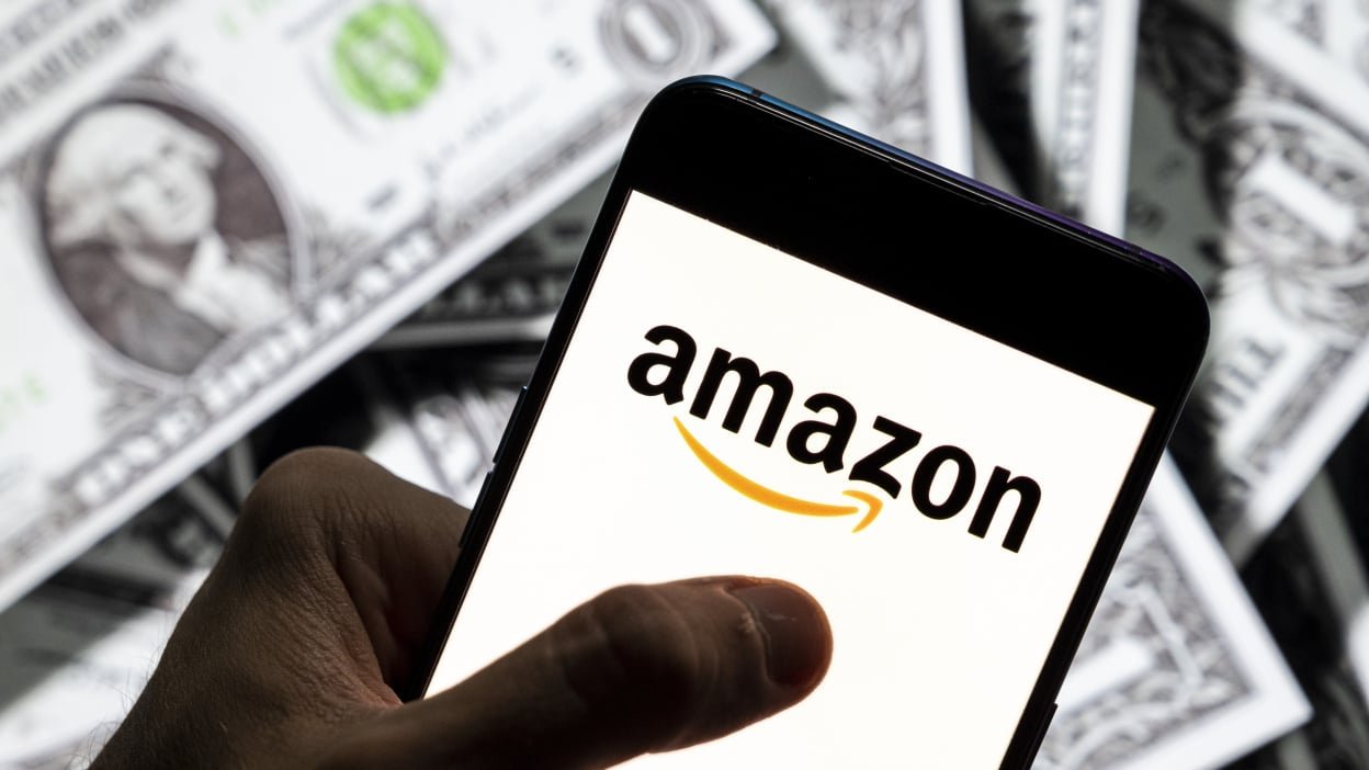 Amazon logo with dollars behind it